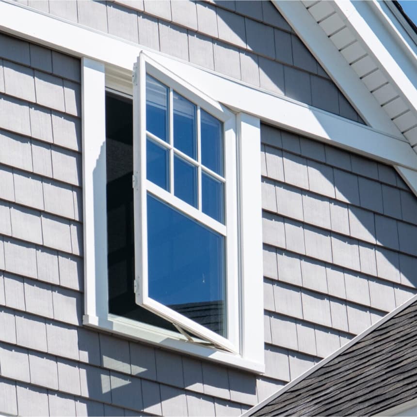 Casement window in the top floor of a Cape Cod style home