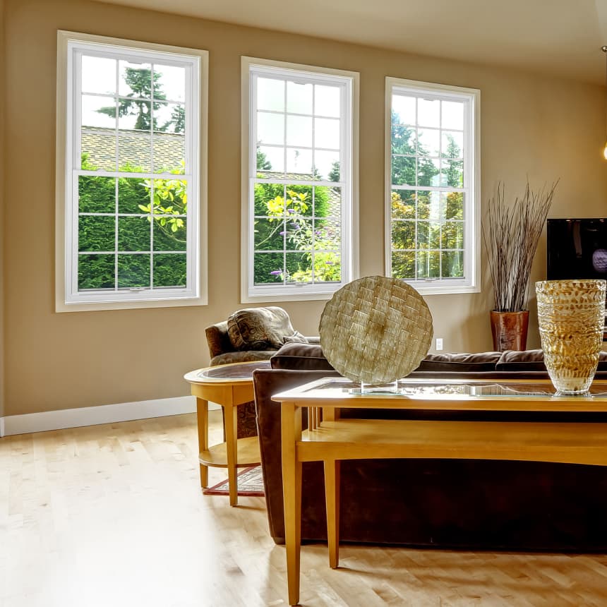 Three double-hung windows along a wall in a living area with a couch