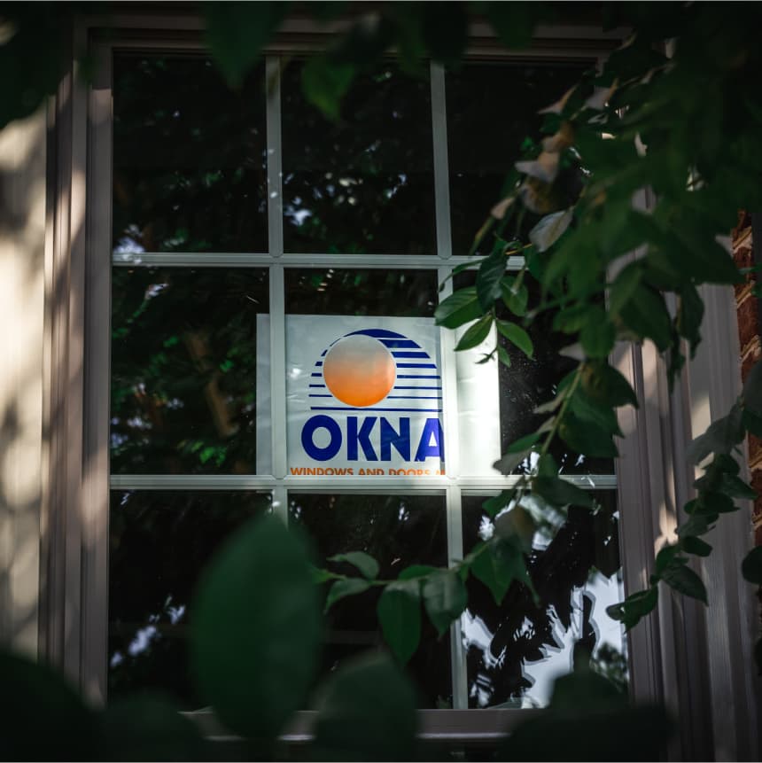 An Okna sign in a shaded window