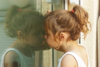 little-girl-looking-through-window.jpg