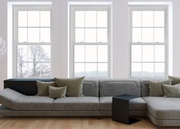 Big comfy couch with three large windows above. 
