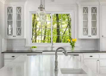 Kitchen with beautiful window over the counter, with trees beyond