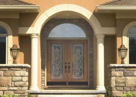 Arched stucco entrance with decorative French door