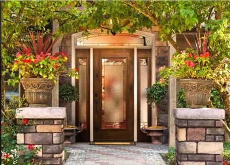 Ornate entry door with sidelights, transom and landscaping