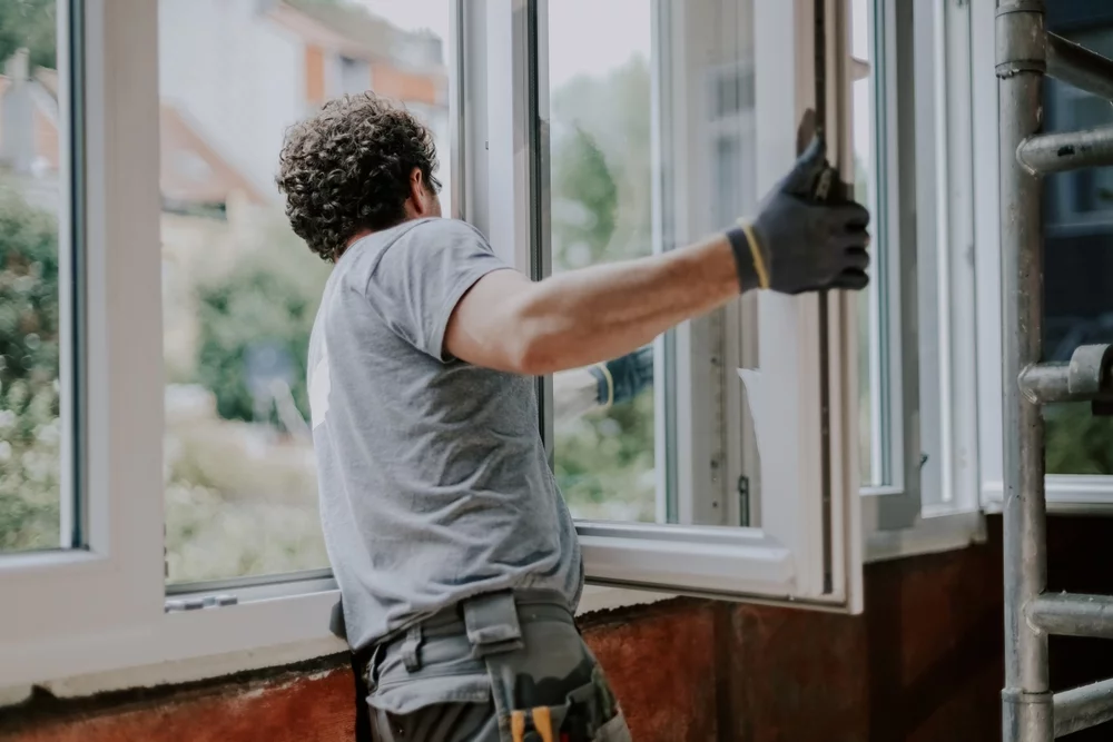 A worker installing a window in a house.
